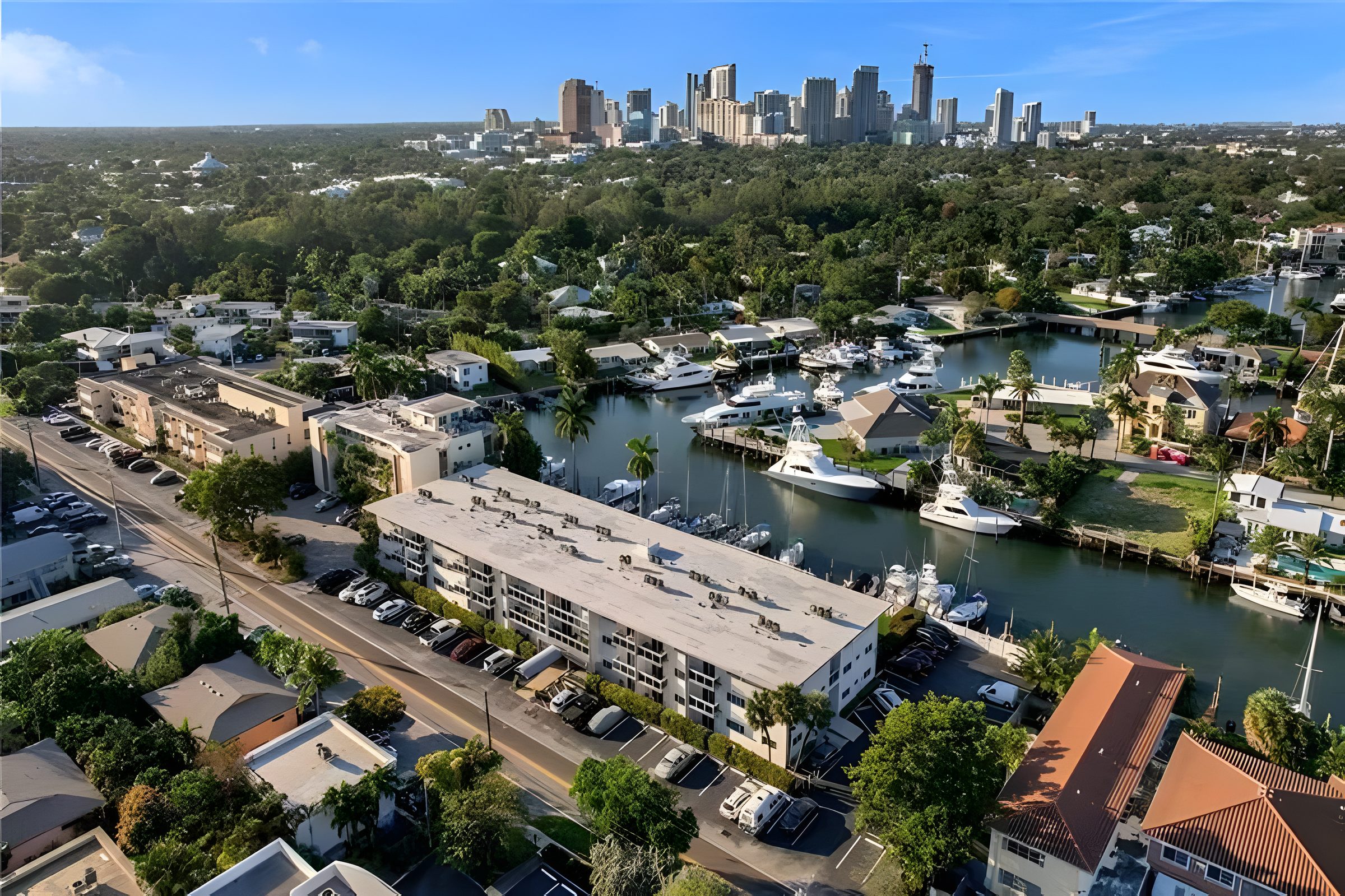 Aerial view over Harbordale showing the canal, moored boats and the downtown Fort Lauderdale skyline behind.