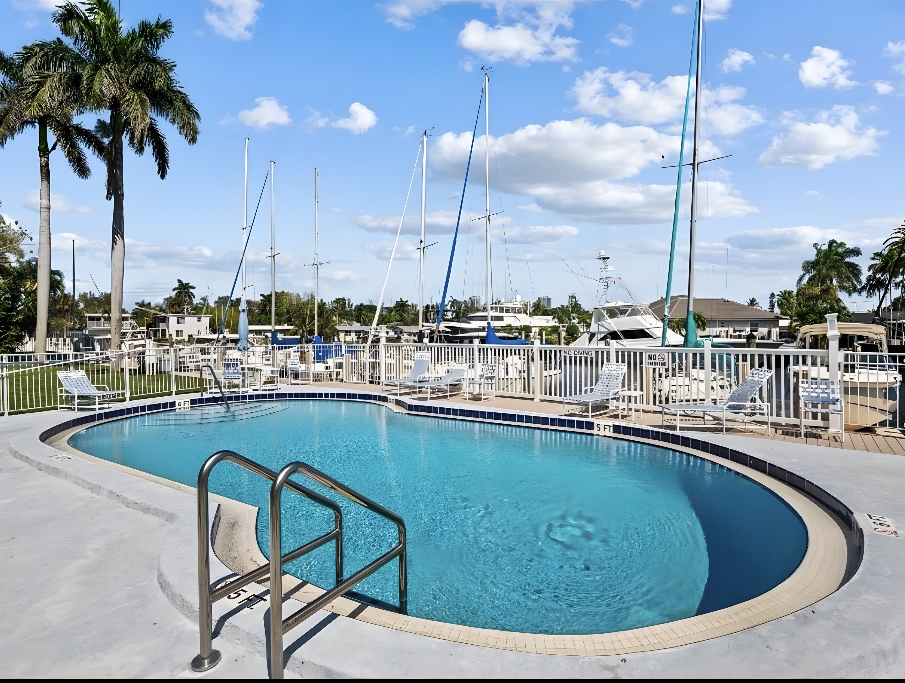 The community pool at Embassy Condominiums, with the masts of the boats moored at the association's slips rising behind it.
